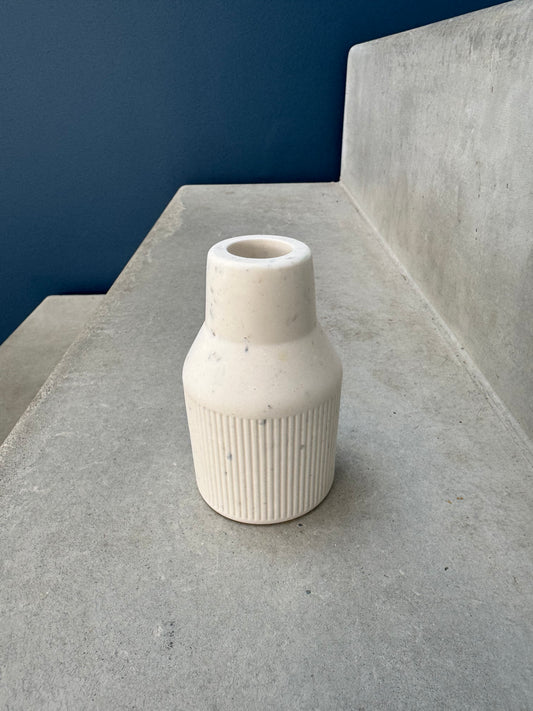 Vase demi-strié ivoire à silhouette de bouteille, sur une marche grise