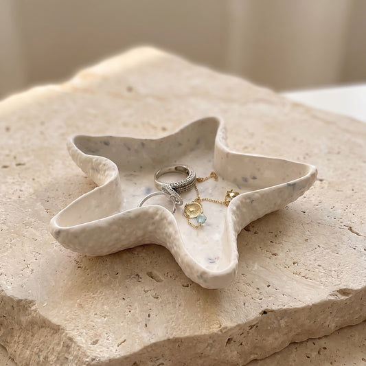 Vide-poche étoile de mer avec bijoux sur pierre claire