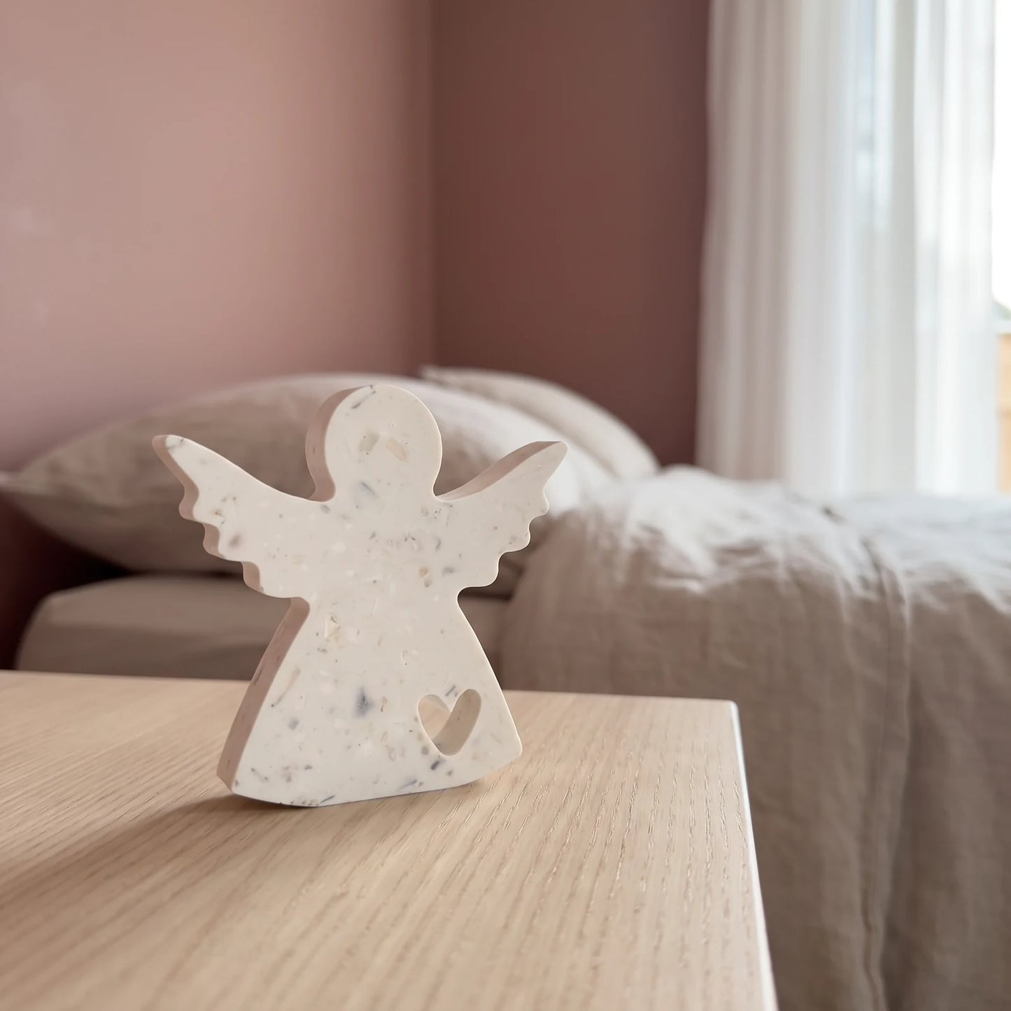 Ange S posé sur une table de chevet dans une chambre contemporaine