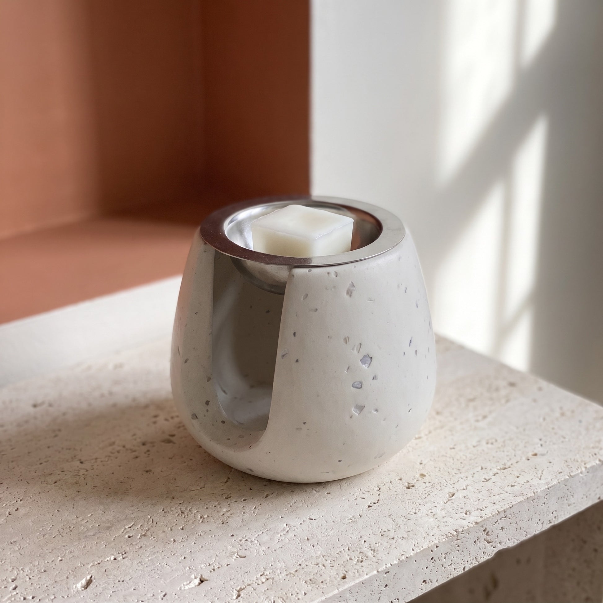 Brûle-parfum artisanal sur une console d’entrée