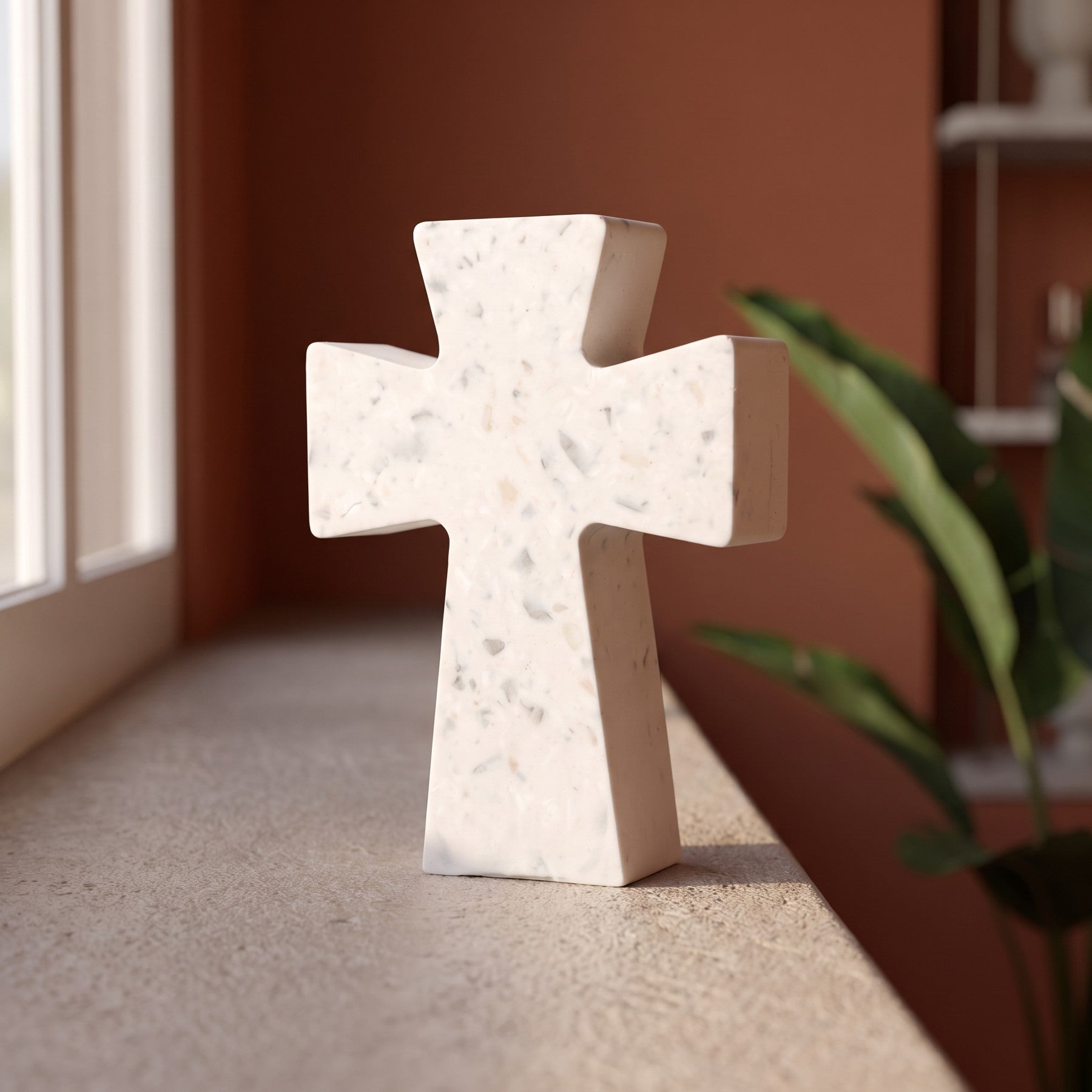 Croix évasée sur une tablette dans un salon aux murs terracotta