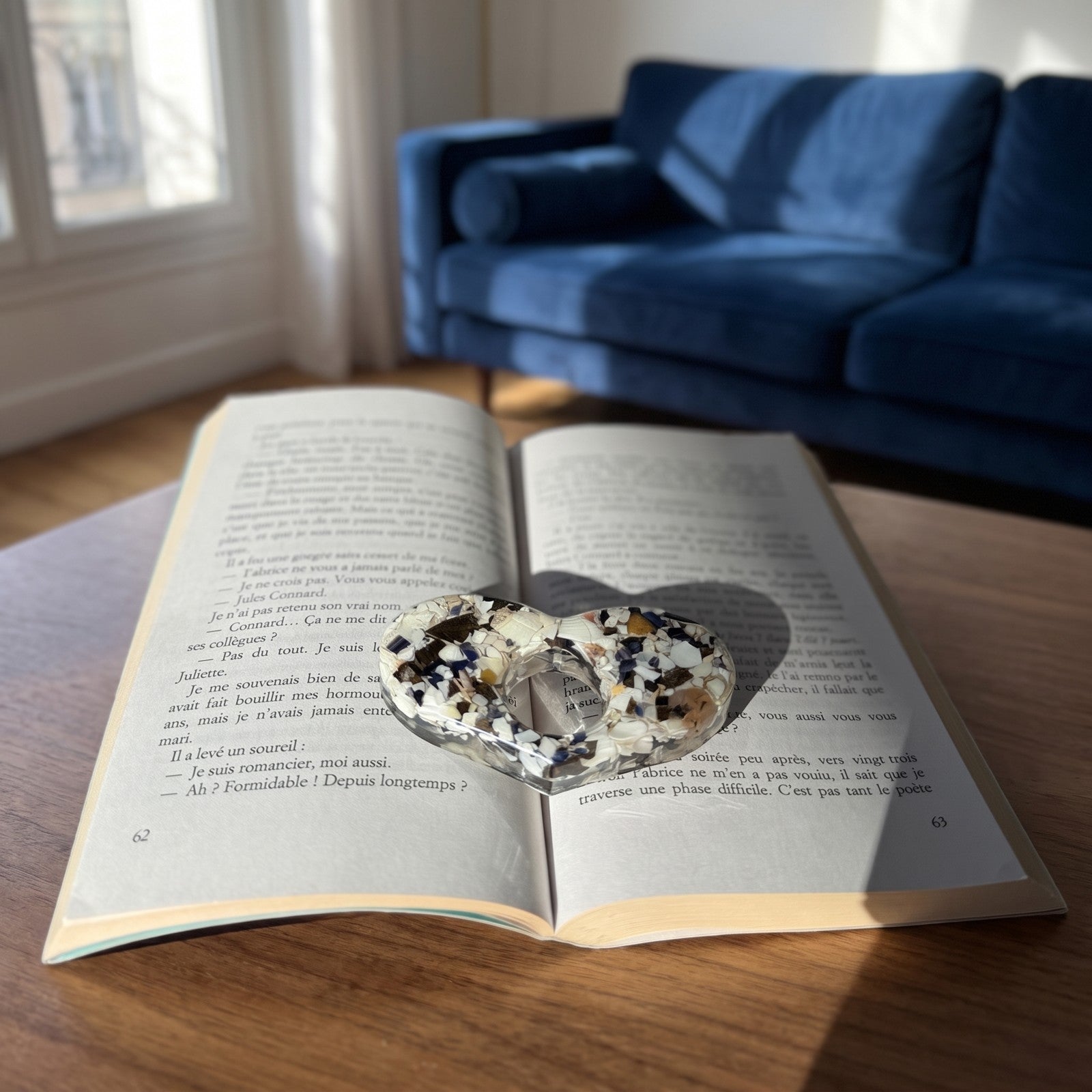 Bague de lecture sur un livre ouvert posé devant un canapé