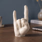 Main rock artisanale sur un bureau en bois devant un mur bleu