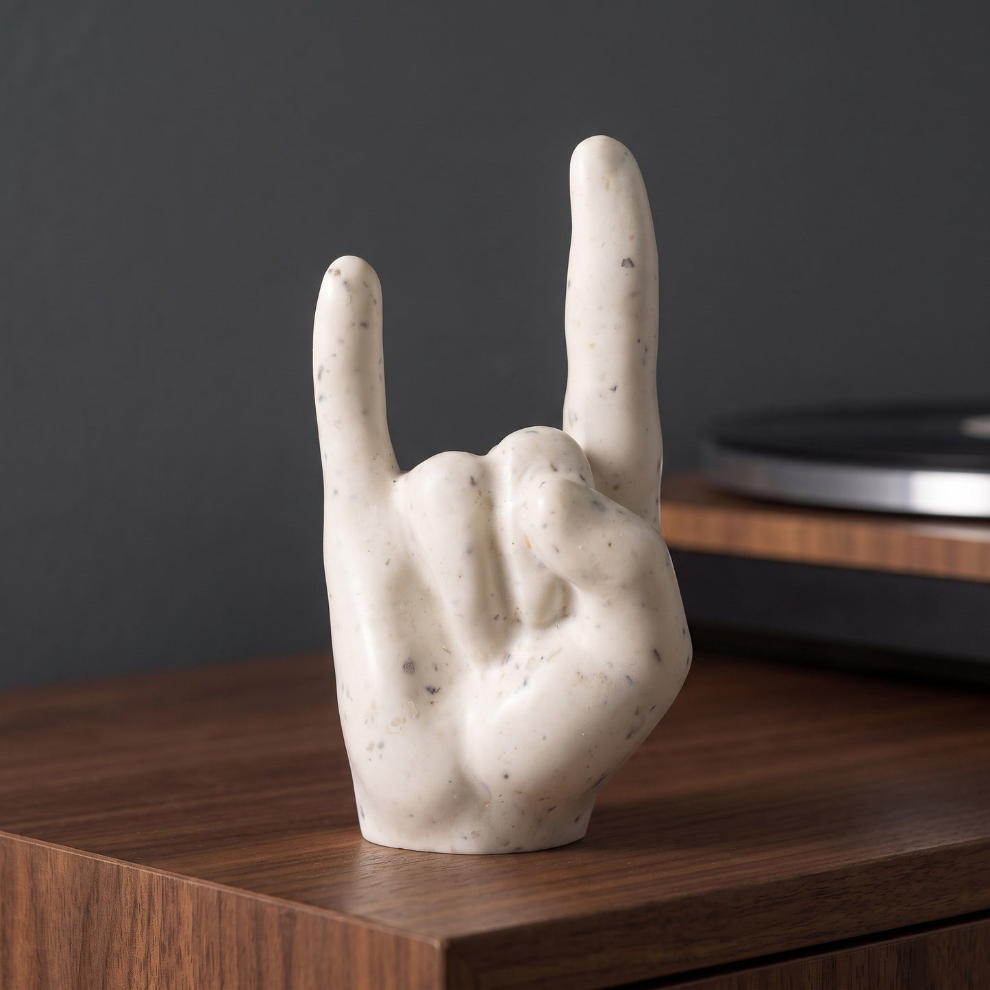 Main rock ivoire sur un meuble en noyer près d’une platine vinyle