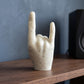 Main rock en coquillages recyclés vue de dos sur une étagère en bois