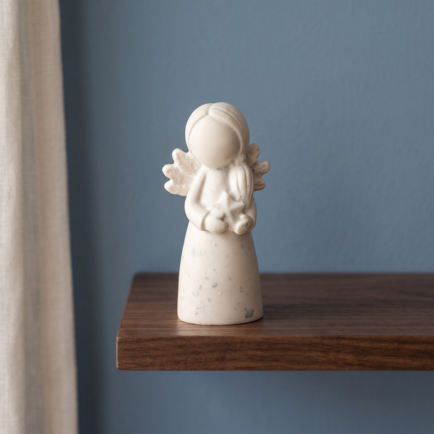 Statuette de fée à robe lisse sur une étagère dans une chambre