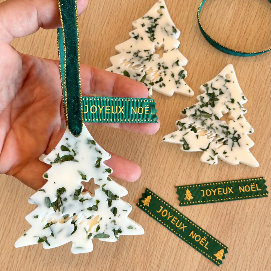 Sapin parfumé La Bougière en main avec ruban Joyeux Noël