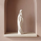 Vierge Marie en prière sur une tablette en pierre dans une niche contemporaine