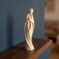 Statuette artisanale de la Vierge Marie sur une étagère en bois